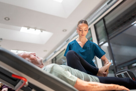 Senior man receiving professional physiotherapy leg
