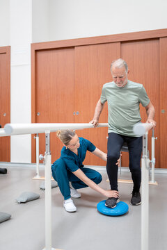 Physiotherapist assisting patient with balance training exercise