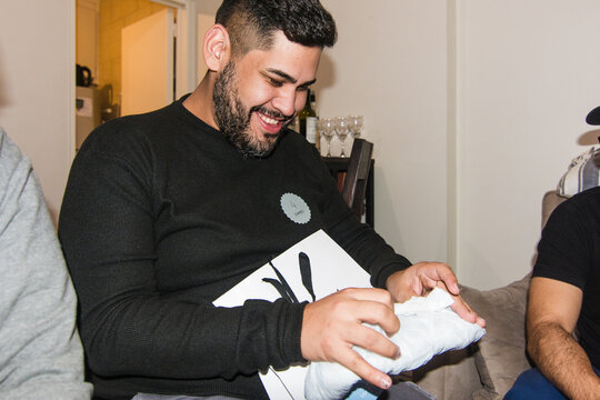 Man opening present at dinner party