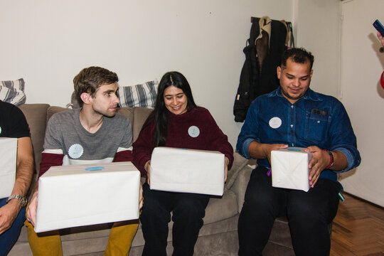 Friends opening gifts at secret santa game