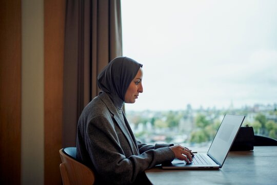 Woman Working on Laptop in Modern Office With City View