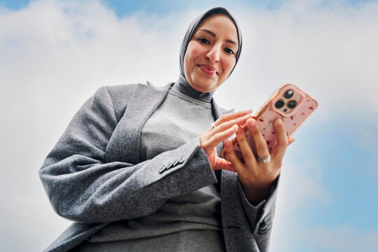 Professional Woman Using Smartphone While Outdoors in Bright Sky