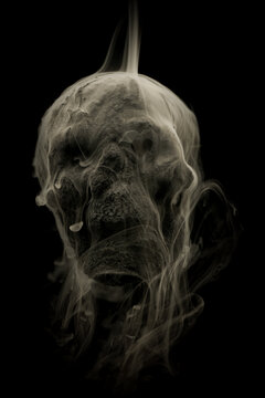 Skull covered in charcoal dust homemade with smoke and dry ice swirling around creating scarry spooky patterns