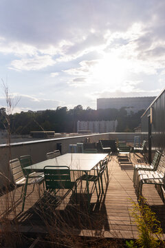 Sunny Rooftop Terrace With Tables and Chairs in Urban Setting