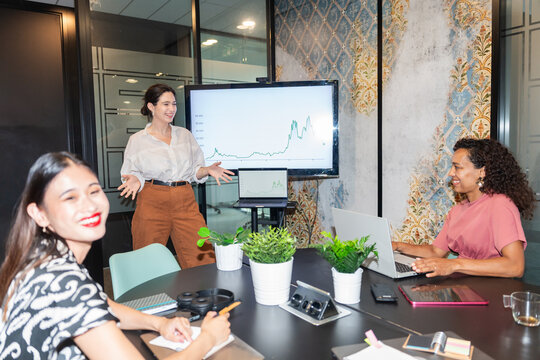 Business Team Meeting With Charts and Discussion in Modern Office