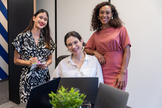 Three Women Collaborate in a Modern Office Setting During the Day