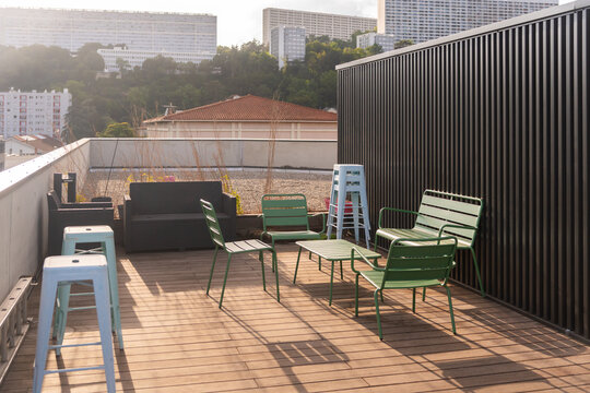 Rooftop Seating Area With Green Chairs and Wooden Floor in the City