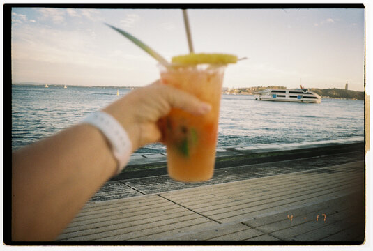 Enjoying a Refreshing Drink by the Waterfront at Sunset