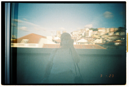 Reflection of a Person Taking a Photo With City Skyline Backdrop