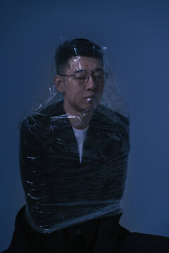 A lonely man wearing a plastic bag