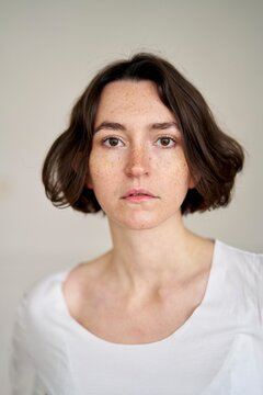 Soft Lighting Reveals a Contemplative Young Woman With Freckles
