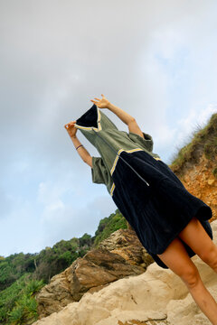 Surfer changing with a towel poncho at the beach