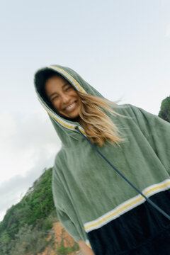 Smiling woman in towel poncho with motion blur