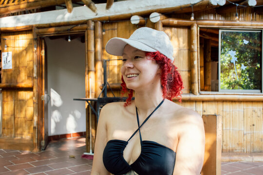 Smiling Woman With Red Curls Enjoying a Sunny Moment Outdoors