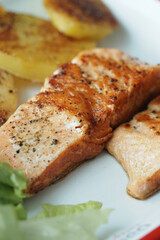 Salmon fillet served with roasted potatoes and lettuce