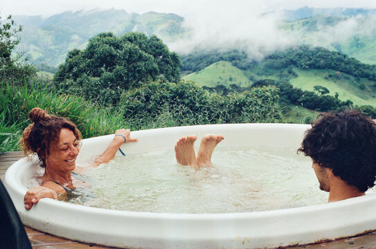 Mother and son relaxing in a jacuzzi with mountains in the background