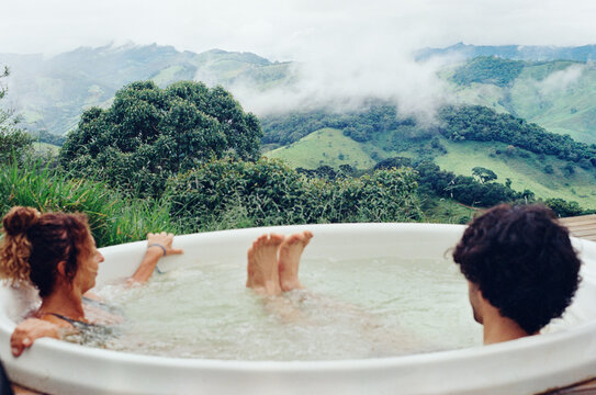 Mother and son resting in a jacuzzi with mountains in the background