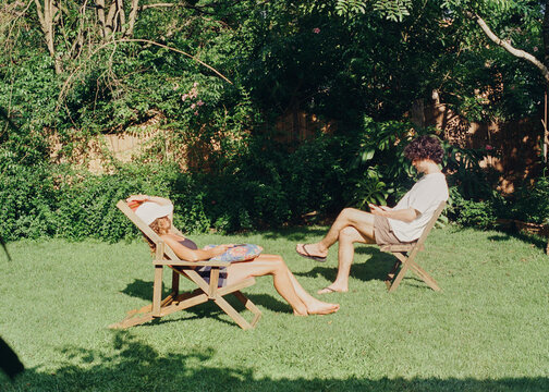Mother and son sunbathing relaxing in the backward 