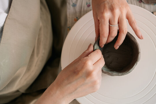 Creating Pottery Bowl With Clay on a Spinning Wheel