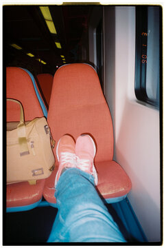 Footwear Resting on Seat in an Empty Train 
