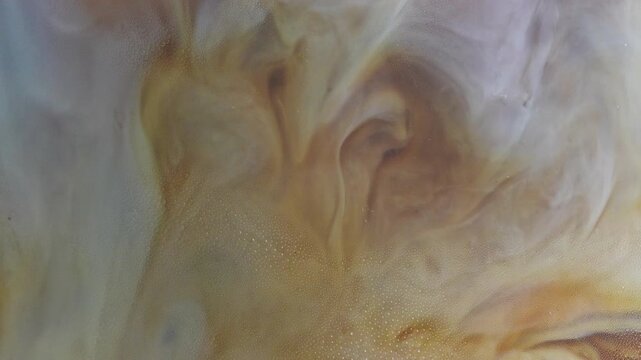4K Milk swirling into coffee abstract marble patterns Close up beverage background with creamy texture, minimal cafe concept and soft liquid motion.