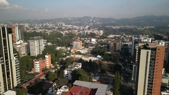 Aerial panning above zona 14 in downtown Guatemala City mountains and skyscrapers