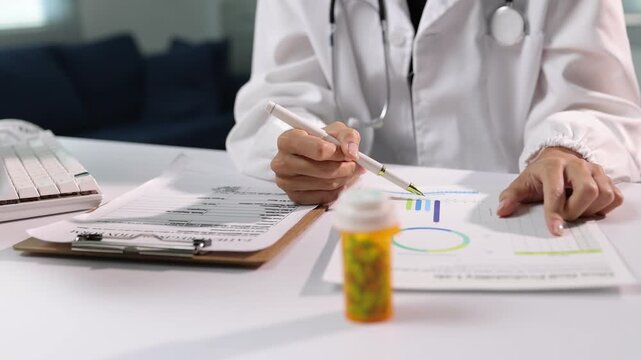 The doctor is analyzing the results of a drug trial. Female physician examining patient's medical data and graphs on her desk.
