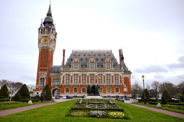 Panoramic view of Calais town hall and belfry tower with landscaped garden under cloudy sky Calais France