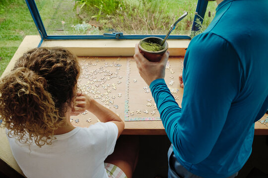 Mother and mature son working together to solve a puzzle