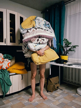 Person carrying huge laundry pile burden