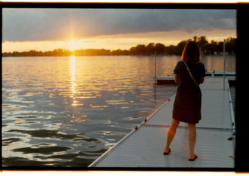 Sunset View From Dock With a Woman Looking at the Lake