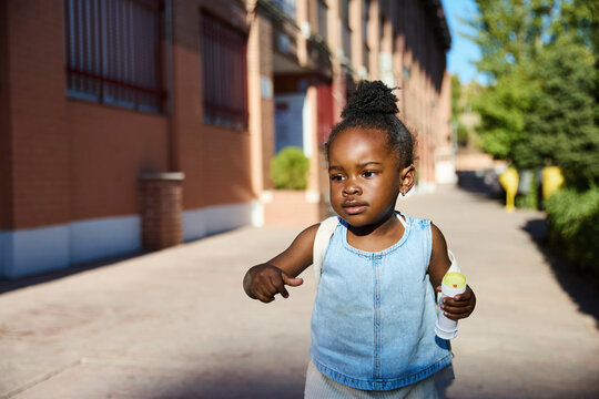 Child walking toward school building in morning light