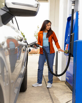Asian woman travel pumping gas at station 