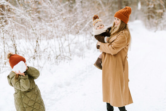 Mother and children playing in snowy forest