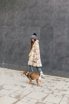 A woman walks her mixed-breed dog