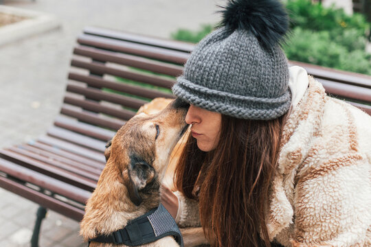 A woman cuddling with her mixed-breed dog 