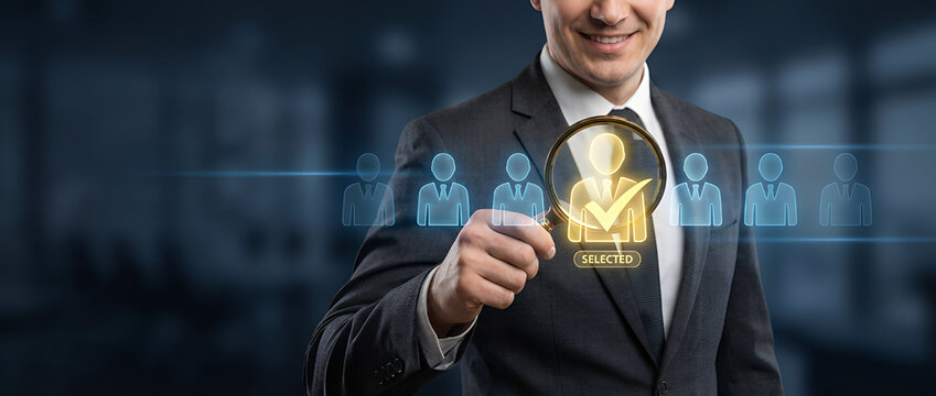 Business professional holding magnifying glass highlighting selected candidate icon, illustrating recruitment screening, talent selection, human resource management new
