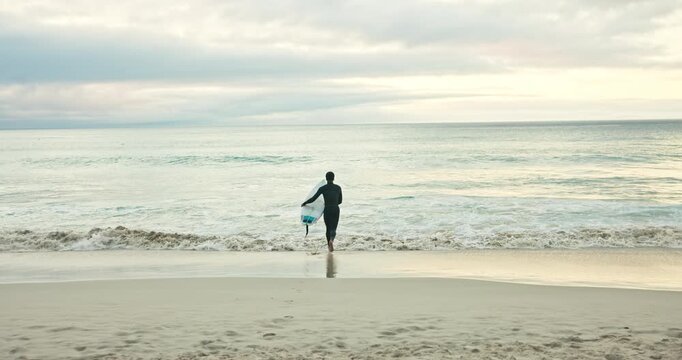 Running, waves and man on beach with surfboard for water sports, adventure and hobby on holiday. Surfer, nature and back of person ready for surfing activity in ocean on vacation, break and weekend
