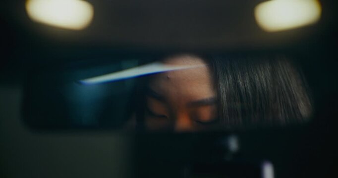 Close Up of Young Asian Woman Adjusting Rearview Mirror. Eyes Reflected in Glass Female Carefully Aligns Mirror Ensure Perfect Visibility. Mindful Living, Road Safety Awareness, Modern Transportation.