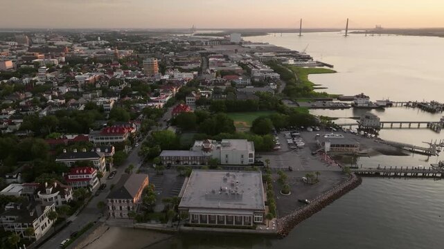 Panoramic Aerial view of Arthur Ravenel Jr. Bridge and surrounding downtown Charleston, South Carolina skyline cityscape landscape with bay water and city landmarks during morning sunrise light - 4K D