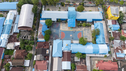 Aerial shot shows schools and basketball courts in Banjarmasin city under blue skies © A Denny Syahputra