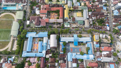 Aerial view of a Banjarmasin stadium surrounded by buildings and courts during the day