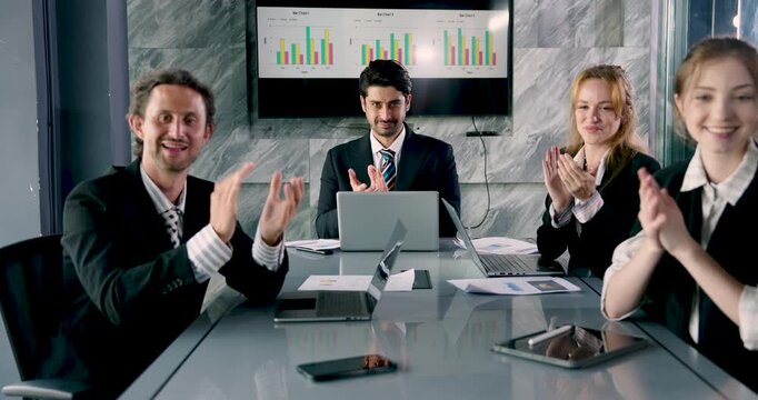 Smiling professionals applauding together in business meeting, corporate team acknowledging achievement with joyful expressions, diverse group working in positive collaborative atmosphere
