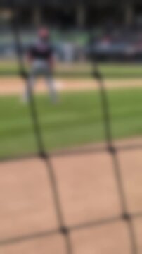 Baseball running coach walks down the foul line after a pitch