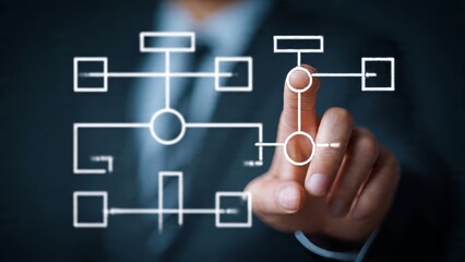 Obraz premium Businessman interacting with a digital flowchart on a futuristic interface showing organizational structure and strategy