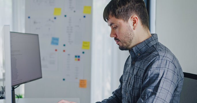 Young adult male freelance developer typing write prompt AI bot app program nomad terminal with coding at office. Artificial intelligence dashboard, robotics, user interface, machine learning concept.