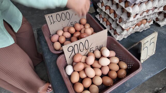 Woman Hand Picking Chicken Eggs at Market