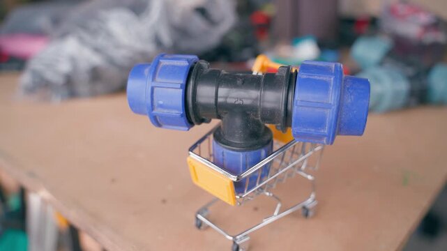 Three outlet water pipe adapter being placed in shopping cart, close-up