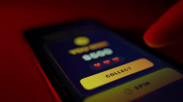 The user plays slots on a mobile app and spins with a win. Gambling on smartphones