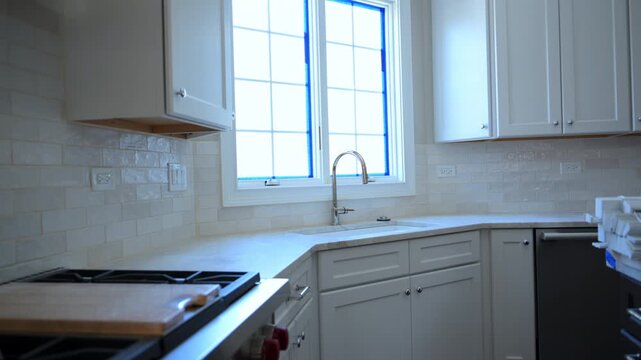Modern kitchen with white cabinets and sink by the window, professional kitchen cabinet installation service and home renovation concept.